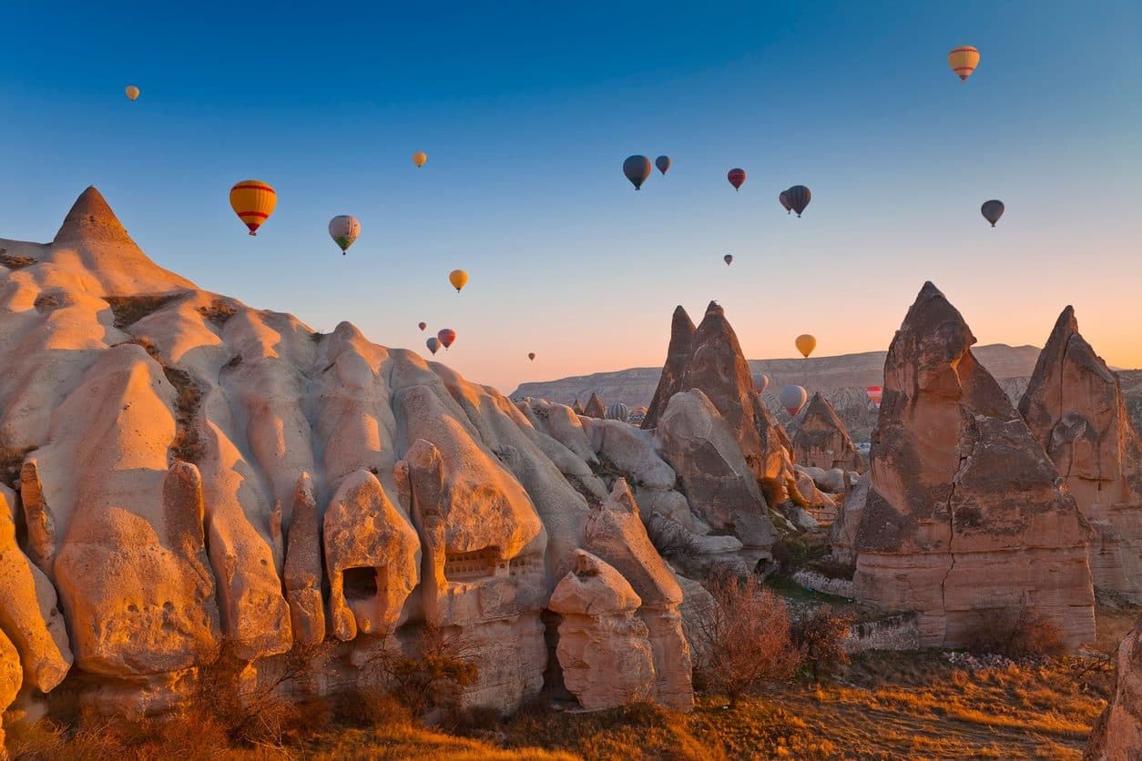 Hot air balloons over the fairy chimneys of Cappadocia at sunrise