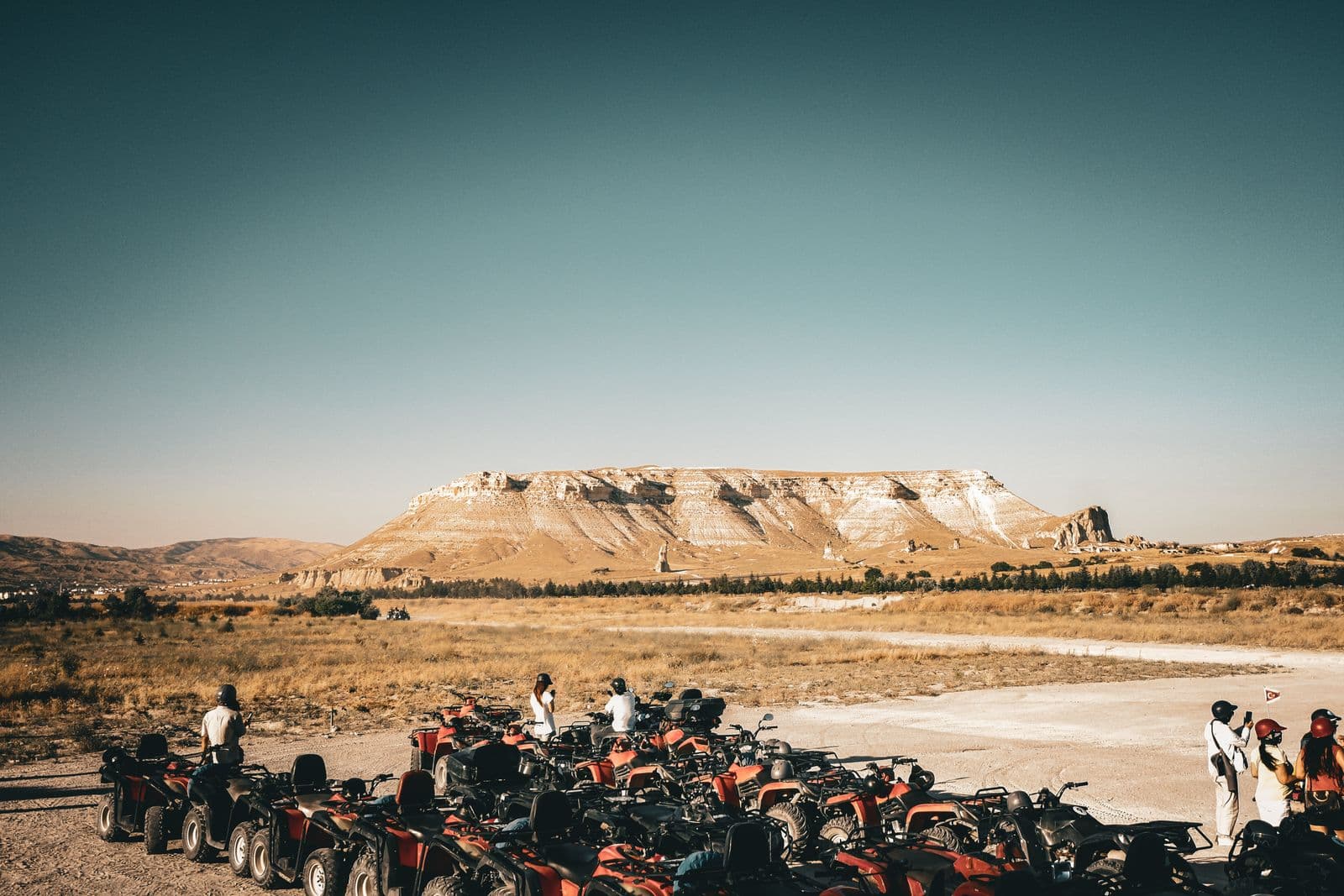 A group on ATVs at a viewpoint over the Cappadocia valleys