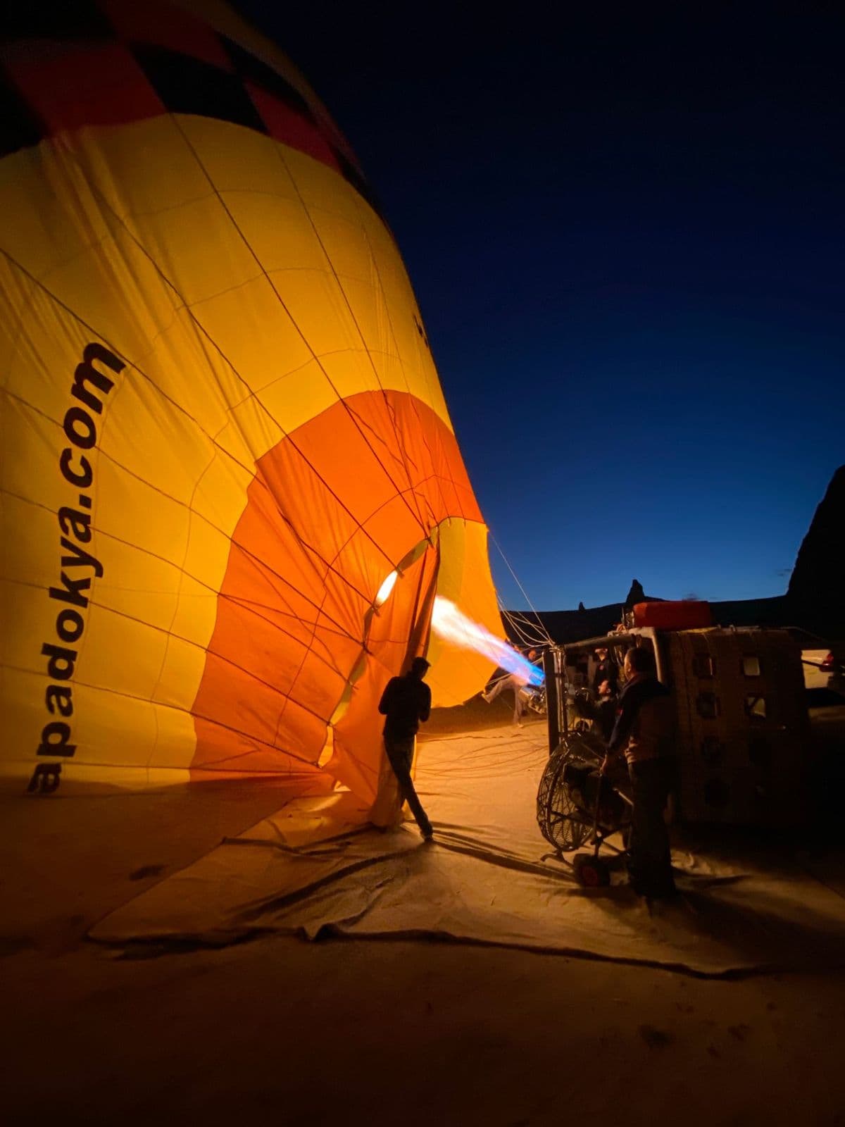 A hot air balloon being inflated in the dark before a private sunrise flight