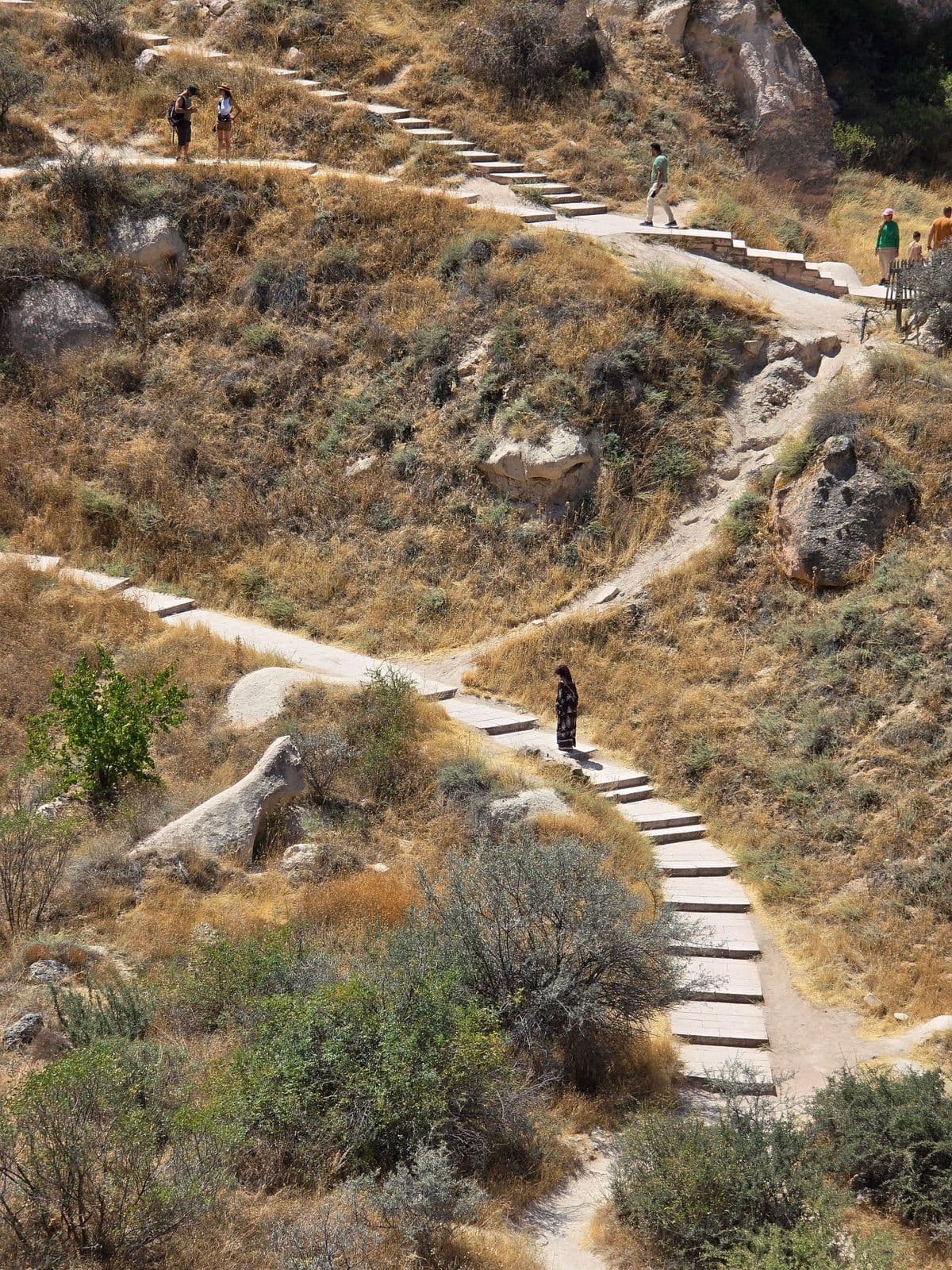 A hiker on a winding trail through a Cappadocia valley